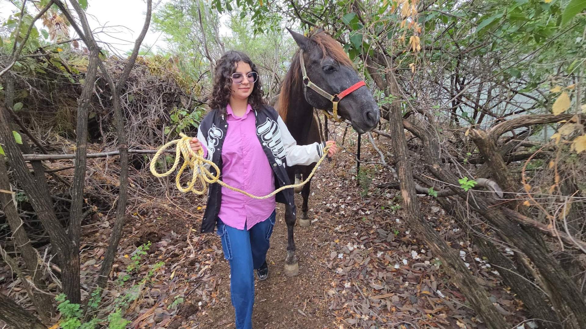 Alumna caminando junto a su caballo